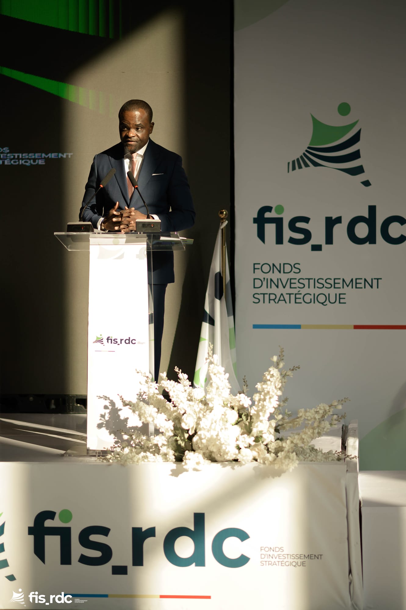 Émile OSUMBA prononce son allocution devant le logo du FIS-RDC.